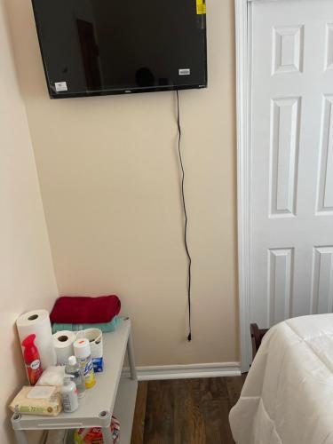 uma televisão pendurada na parede de um quarto em Home away from home em Laurelton