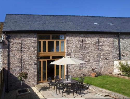 a table with an umbrella in front of a building at Marina View, Near Canal and Mountains in Brecon