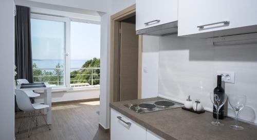 a kitchen with a counter with a sink and a window at Comfort Zovko in Mlini