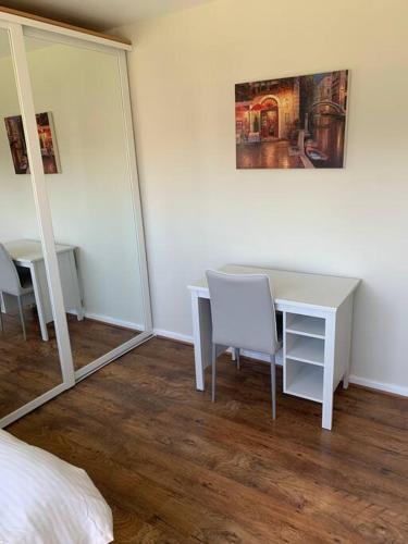 a bedroom with a table and chairs and a mirror at Spacious 2 Bed Elstree Borehamwood Hertfordshire in Elstree