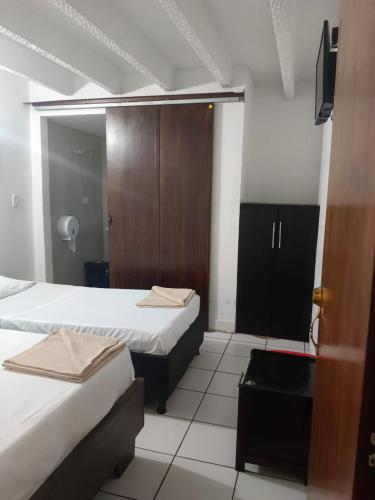Habitación de hotel con 2 camas y armario en HOGAR DE PASO GUARACAO, en Bucaramanga