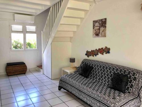 un salon avec un canapé et un escalier dans l'établissement Superbe Duplex résidence privée et piscine, à Saint-François