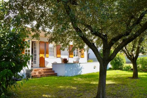 ein weißes Haus mit einem Baum im Hof in der Unterkunft Canevon Suite Apartment in Bardolino