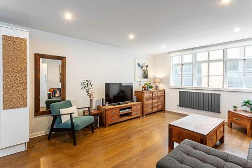 a living room with a tv and a couch and a table at Blackfriars Printhouse Retreat in London