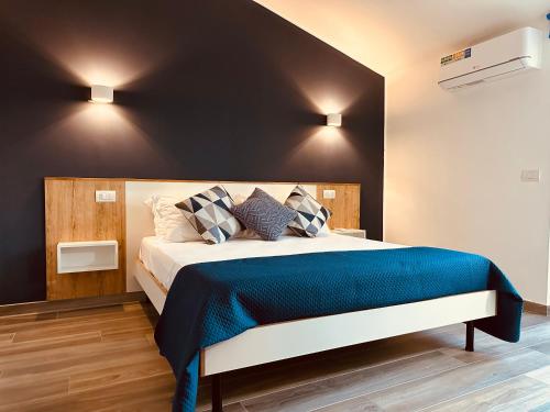 een slaapkamer met een groot bed en een blauwe deken bij Tropea Family Rooms - B&B Il Cavallino in Tropea