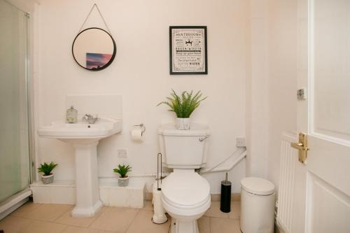 a white bathroom with a toilet and a sink at LARGE CITY CENTRE PROPERTY in Derby