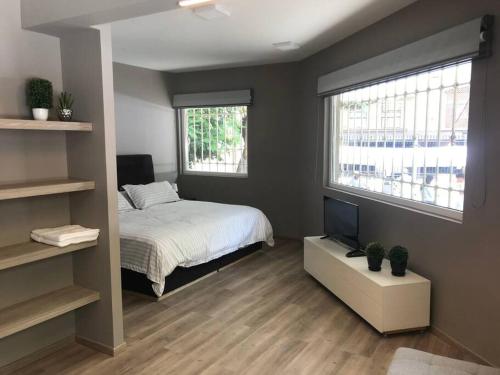 a bedroom with a bed and a television in it at Loft Trendy en PB - WTC - Parque Delta - Facturamos in Mexico City