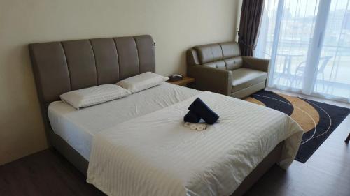 a bedroom with two beds with a stuffed animal on the bed at SleepRest @ NTC in Nagoya