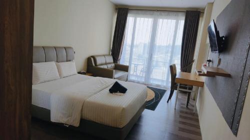 a hotel room with a bed and a desk and a television at SleepRest @ NTC in Nagoya