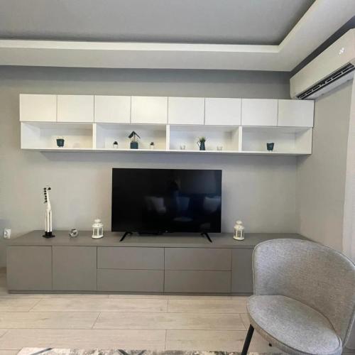a living room with a television and a chair at Apartman Film City in Žarkovo