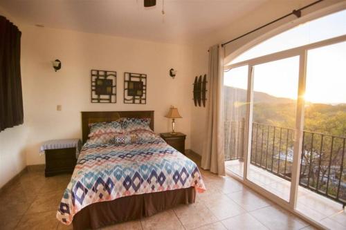 a bedroom with a bed and a large window at Casa de Gigi in Playa Hermosa
