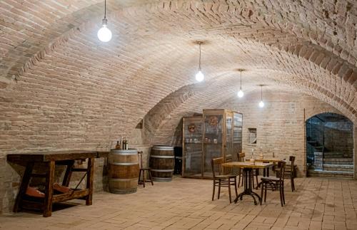Fermo della Guazzona في بوسيتو: غرفة بها طاولات وكراسي وجدار من الطوب