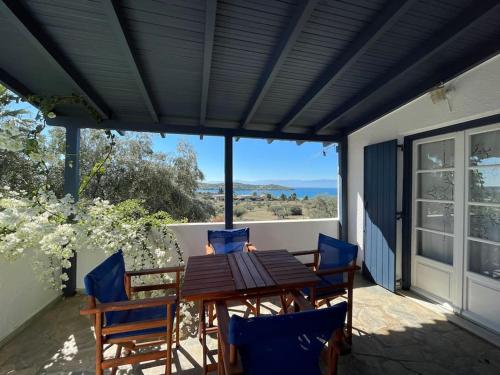 a patio with a table and chairs and a view of the ocean at Villa Evridiki - Walking distance to beach in Porto Heli
