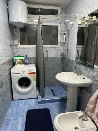 ein Badezimmer mit Waschmaschine und Waschbecken in der Unterkunft Apartman 2E in Tuzla