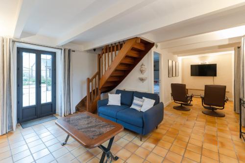 ein Wohnzimmer mit einem blauen Sofa und einer Treppe in der Unterkunft TY MELEN - Charmante maison bretonne proche mer in Plouguerneau