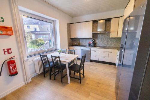 a kitchen with a table and chairs and a window at Tram station rooms by CityPillow since 2019 in Hesperange