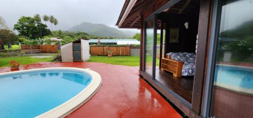 a swimming pool on a patio next to a house at Heipoe Lodge in Uturoa