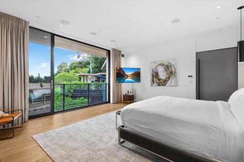 una camera con un grande letto e una grande finestra di Beverly Hillside Haven a Los Angeles