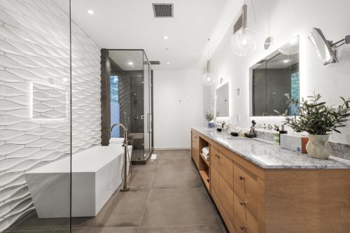 a bathroom with a large tub and a sink at Beverly Hillside Haven in Los Angeles
