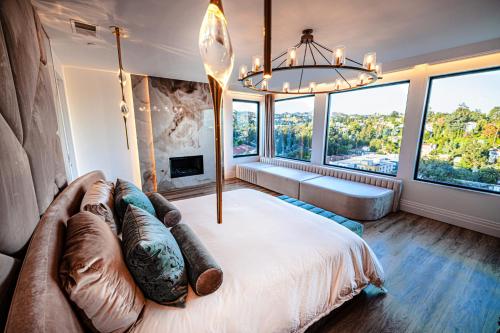 een slaapkamer met een groot bed, een bank en ramen bij Glencoe in Los Angeles