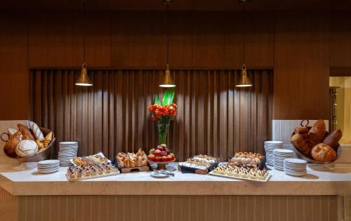 a buffet with bread and pastries on a table at Plaza Camelinas Hotel in Querétaro