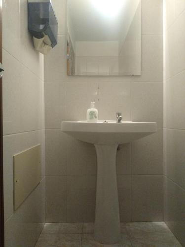 a bathroom with a white sink and a mirror at Melaya Private Rooms in Faro