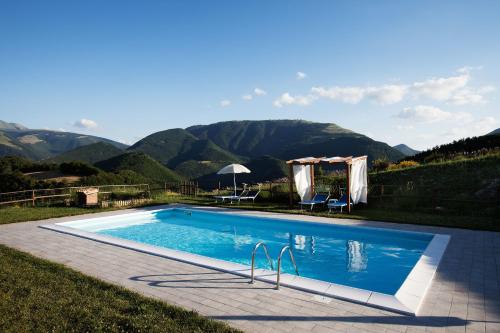 a swimming pool with mountains in the background at Agriturismo Bufano in Cagli
