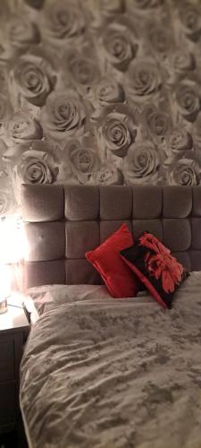 a bed with a head board with roses on it at Cosy Double Room in Harrogate