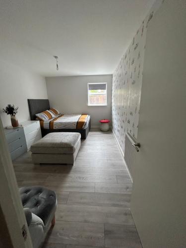 a bedroom with a bed and a couch in a room at Stylish Meets Luxury! 2 Bed 2 Bath Family Home in Dagenham