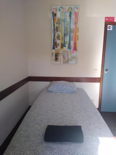a small bed in a room with a picture on the wall at Melaya Private Rooms in Faro