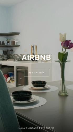 a table with two plates and a vase with flowers at Guanajuato Centro wifi gratis totalmente privado in Guanajuato