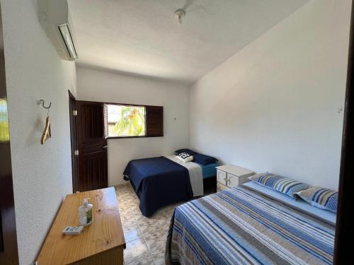 ein Hotelzimmer mit 2 Betten und einem Tisch in der Unterkunft Casa em FRENTE À PRAIA, ao lado do Nord Hotel - Tabatinga in Conde
