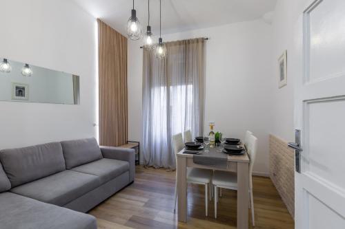 a living room with a couch and a table at Imperium House - appartamento con giardino privato a 3 minuti da Metro Piazza Bologna in Rome