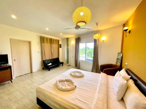 a bedroom with a large bed and a living room at Koimala Hotel in Maamigili