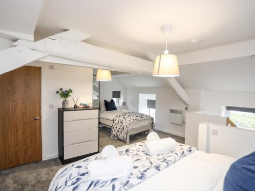 a bedroom with two beds and a mirror at Llety Pen Deitsh 2 in Caernarfon