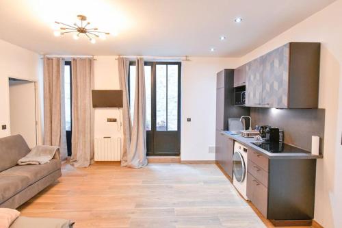 un salon avec un canapé et une cuisine dans l'établissement Suites Sacré-Cœur Basilica, à Paris