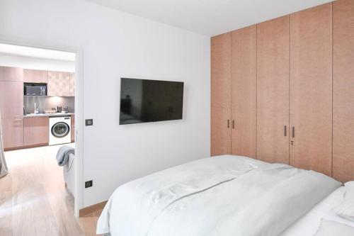 une chambre blanche avec un lit et une cuisine dans l'établissement Suites Sacré-Cœur Basilica, à Paris