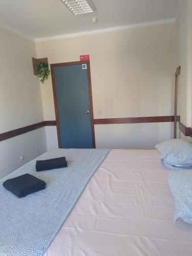a bedroom with a white bed with a door at Melaya Private Rooms in Faro