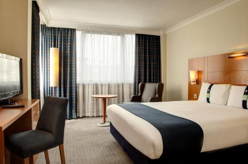 a hotel room with a bed and a television at Holiday Inn London Bloomsbury, an IHG Hotel in London