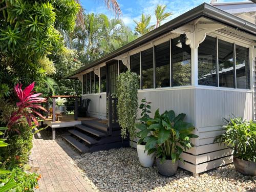 a white screened in porch of a house with plants at Sweet Creek Cottage, Palm Cove, 200m to Beach, Heated Pool, Pets in Palm Cove