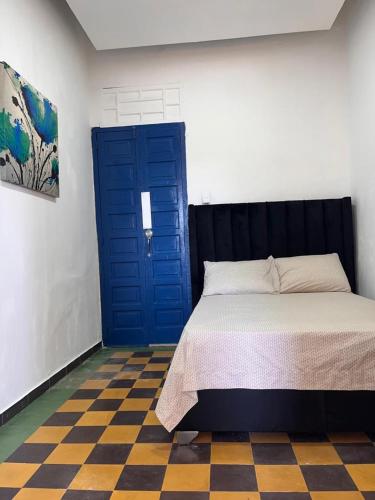 a bedroom with a bed and a blue door at APARTAMENTO ZONA COLONIAL R in Santo Domingo