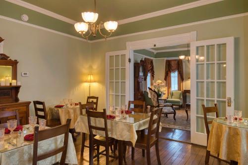 a dining room with tables and chairs and a room at Victorian House Bed and Breakfast in St. Augustine