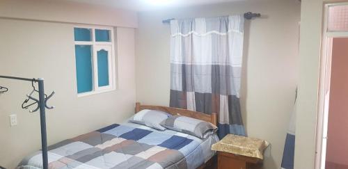 Habitación pequeña con cama y ventana en Expresso Hostel en Sucre