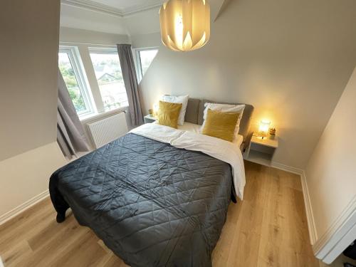 a bedroom with a large bed with yellow pillows at aday - Frederikshavn Penthouse in Frederikshavn
