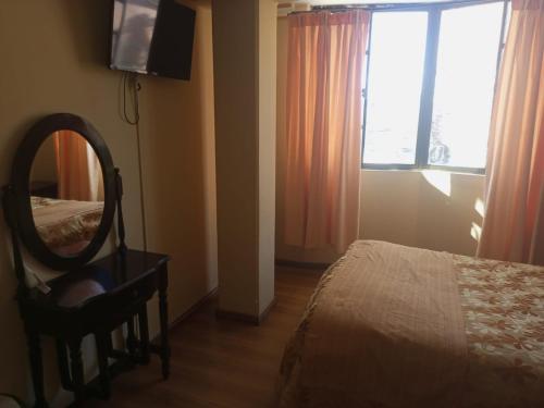 1 dormitorio con espejo, cama y espejo en Hotel el LUCERO, en Oruro