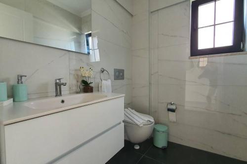 Un baño blanco con lavabo e inodoro. en Dalyan Villa Saki, en Dalyan