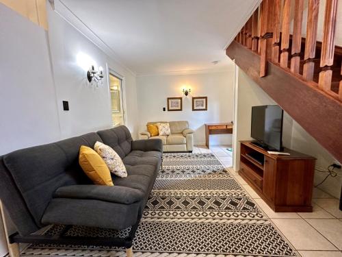 a living room with a couch and a television at Charlesworth On The Park in Glen Innes