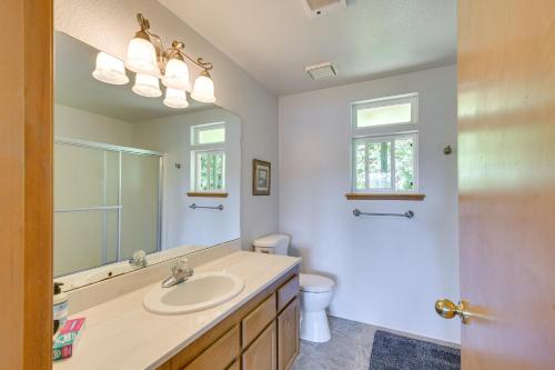 ein Badezimmer mit einem Waschbecken, einem WC und einem Spiegel in der Unterkunft Hoodsport Vacation Rental with Deck and Canal Views! in Hoodsport