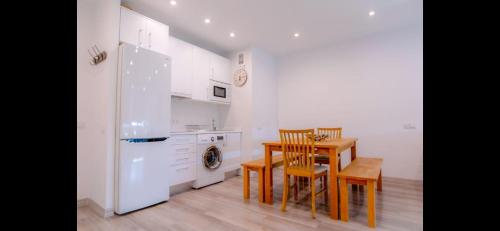 a kitchen with a table and a white refrigerator at Colón Vistas in Madrid
