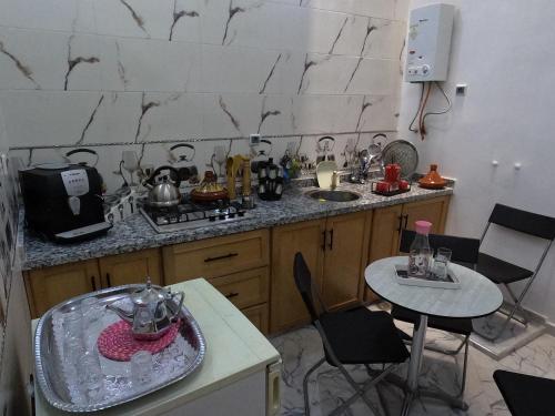a kitchen with a sink and a table with chairs at Tislite d azrou in Azrou